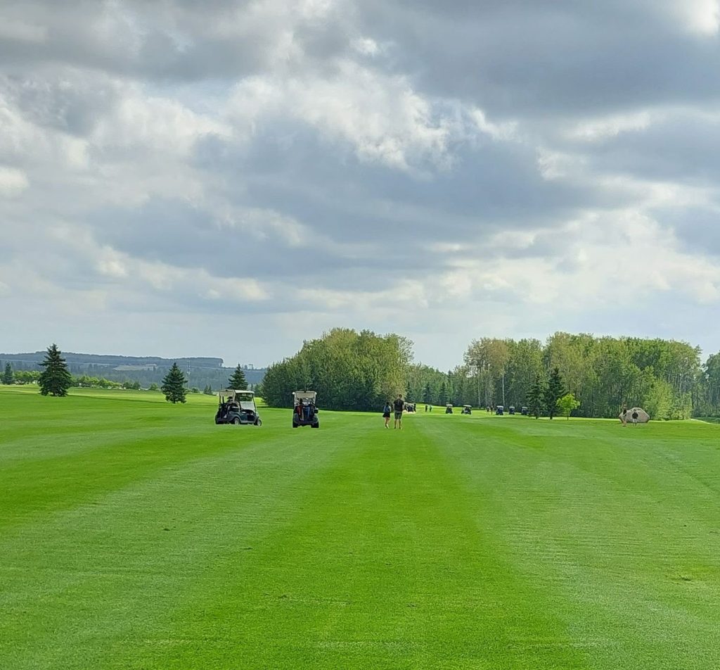 view of golf course fairway with trees in distance